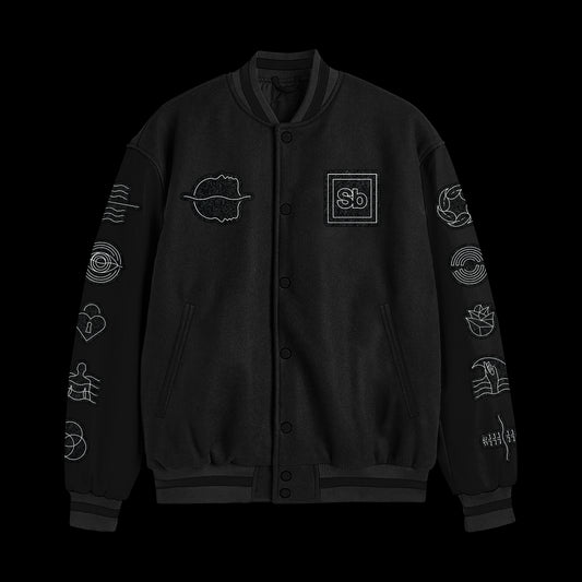 A Spiritbox custom black varsity jacket with white minimalist symbols—abstract shapes, waves, hands, and a “Sb.” logo—chenille embroidered on the chest, sleeves, and shoulders. Displayed on a black background.